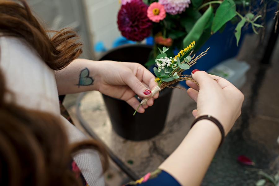 A bridesmaid makes the grooms boutonniere before the ceremony.